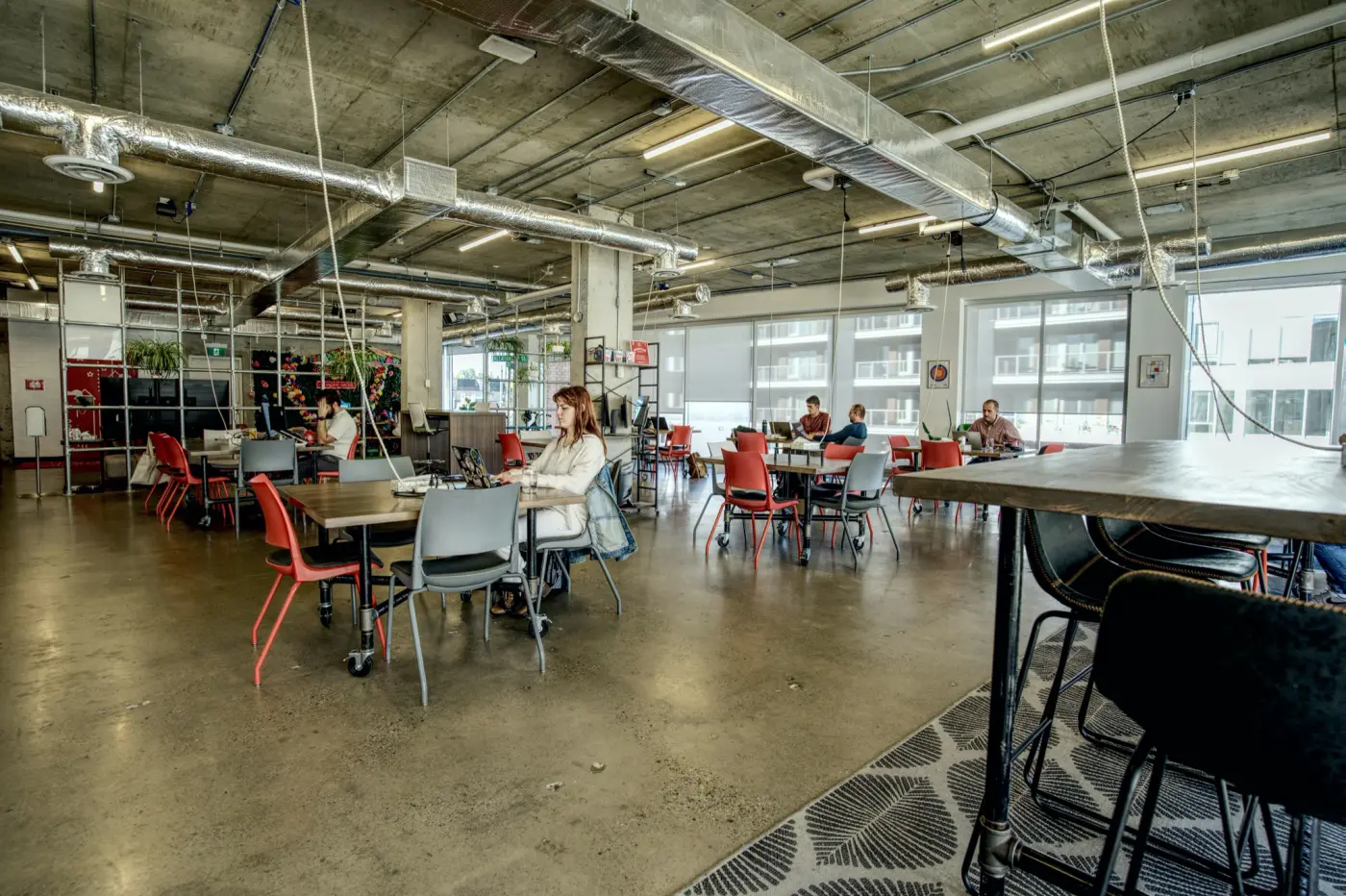 Open seating at Work Nicer Red Mile, tables in front and members at work behind