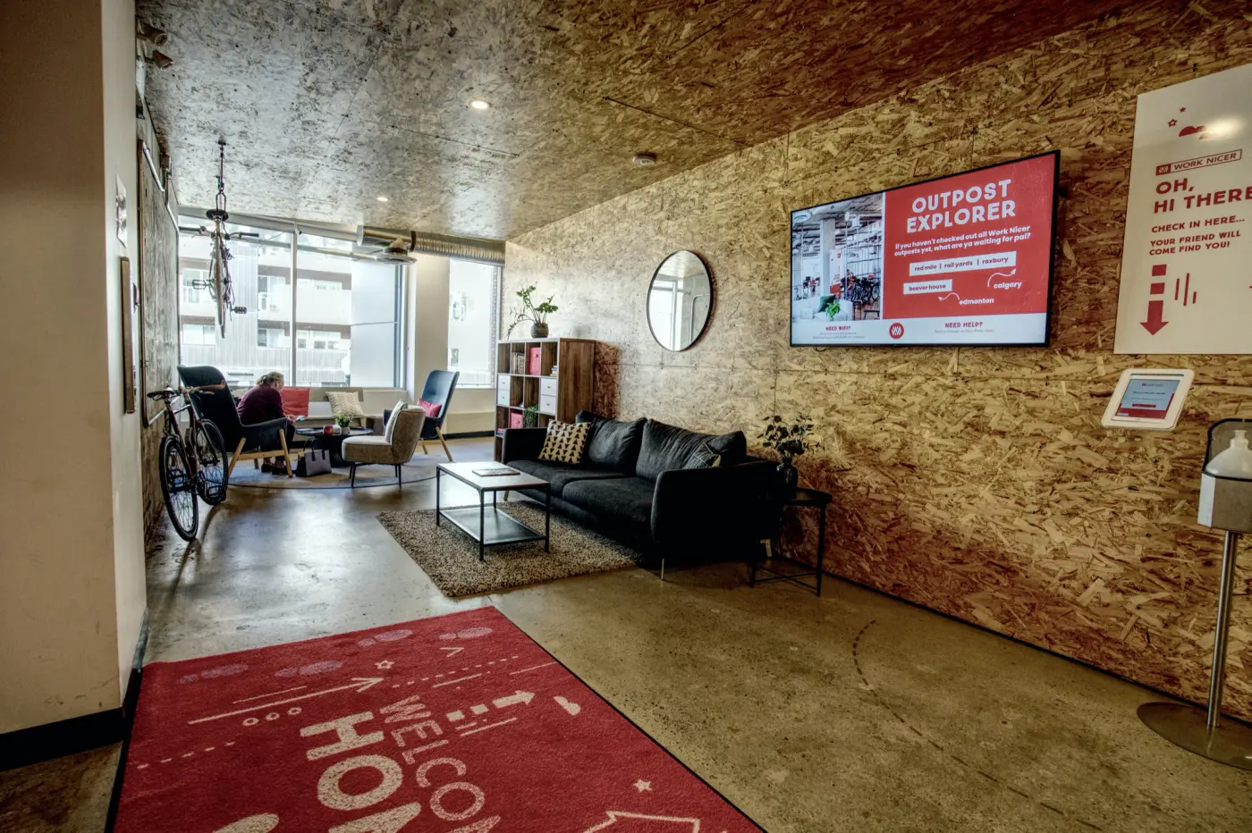 The lounge at Red Mile, with a couch, a screen, and the welcome mat