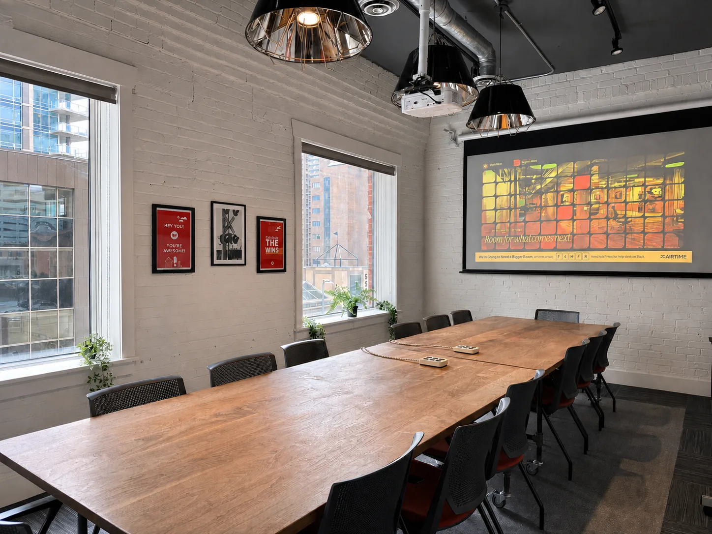 A long wooden boardroom table with a screen at Westcoast