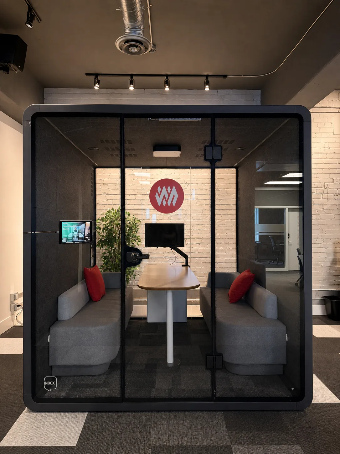 A phone booth with two seats and a screen at Westcoast
