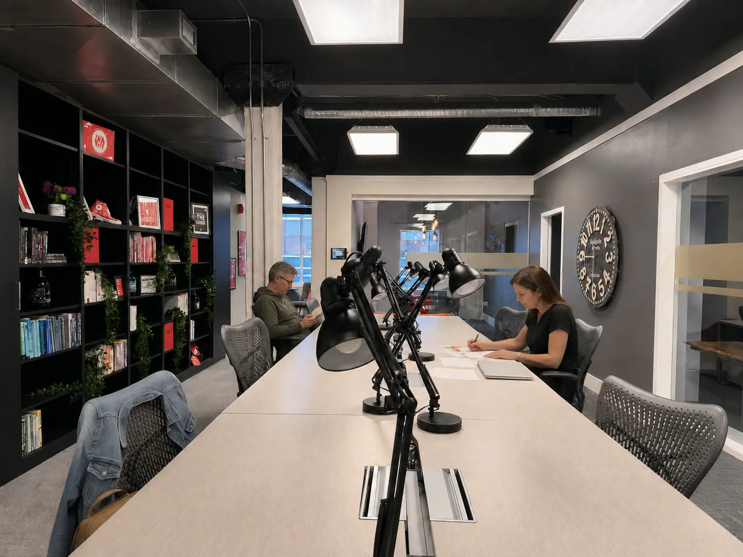 Members working at a long white table beside a wall of shelves at Westcoast