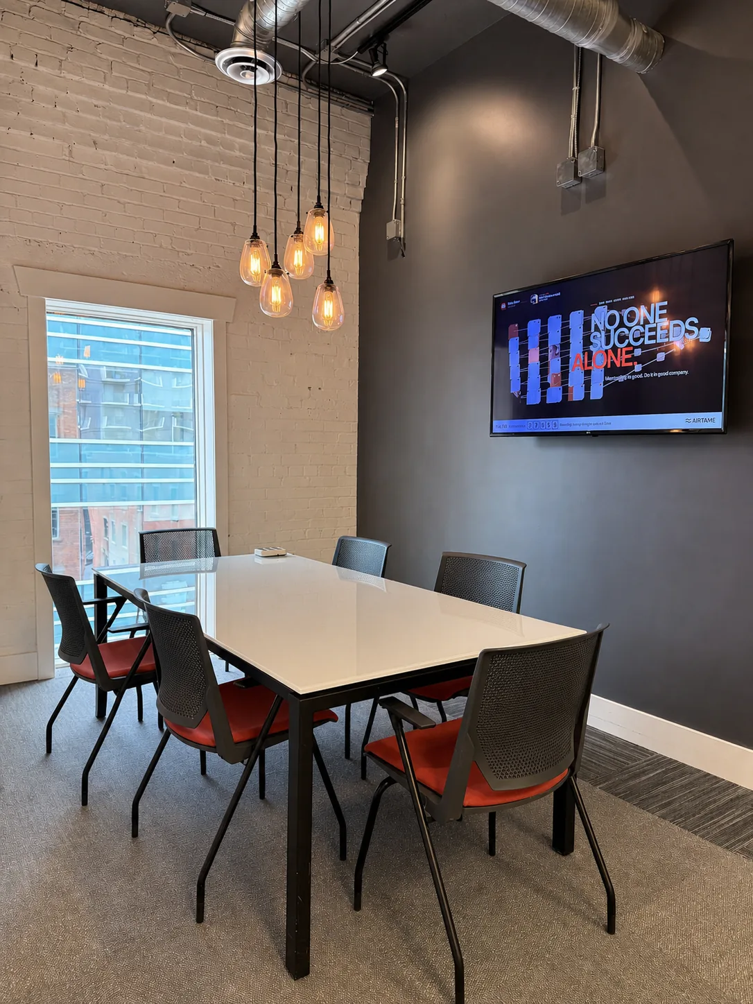 A small meeting room with a white table and a screen at Westcoast