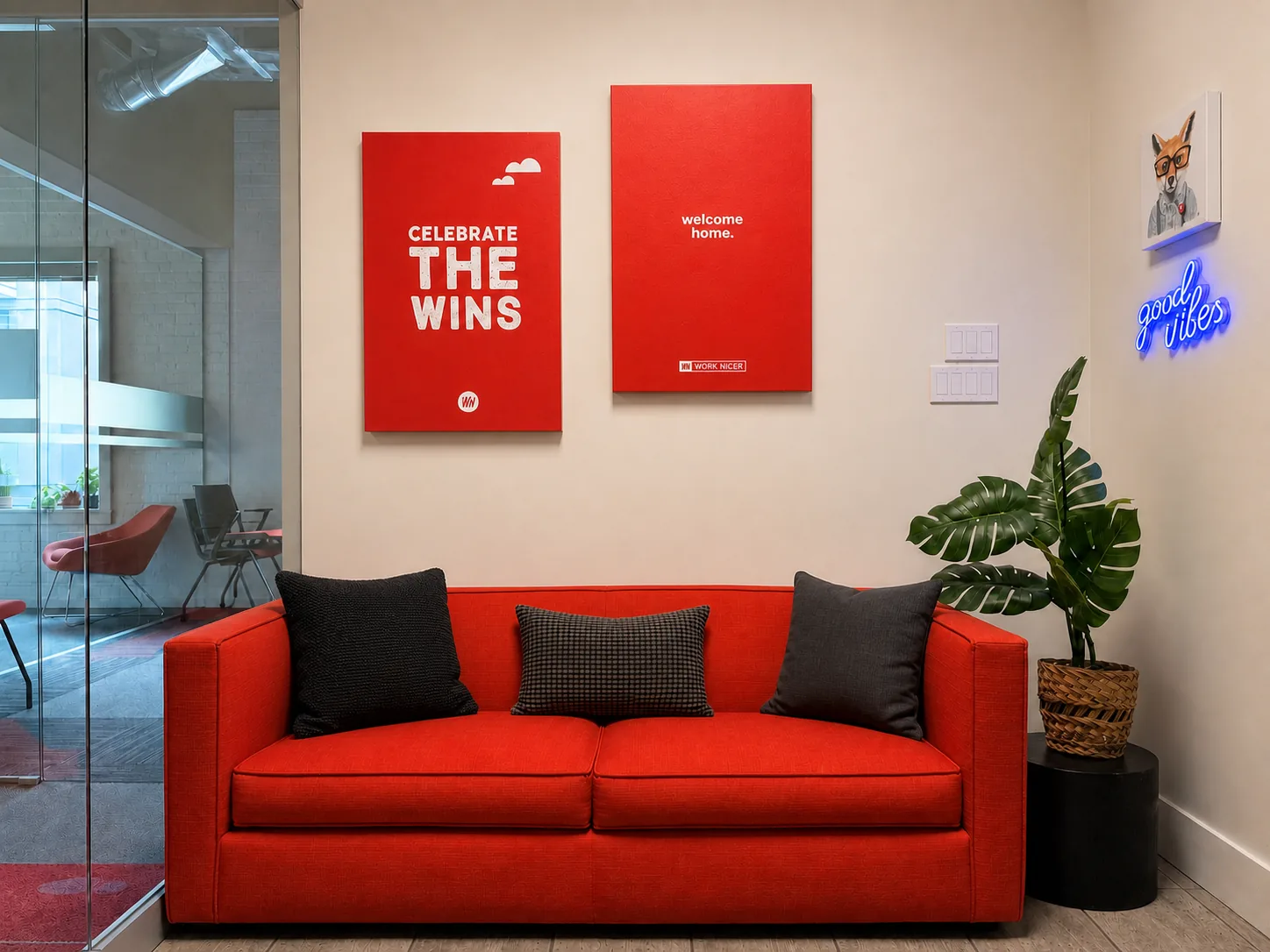 A red couch under two posters that read celebrate the wins and welcome home